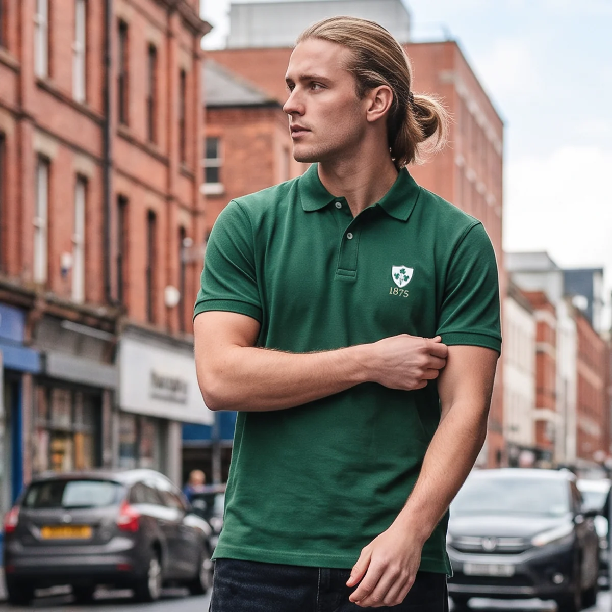 A young man walks along a Dublin street, adjusting the sleeve of the R1823 Ireland 1875 polo shirt he wears.